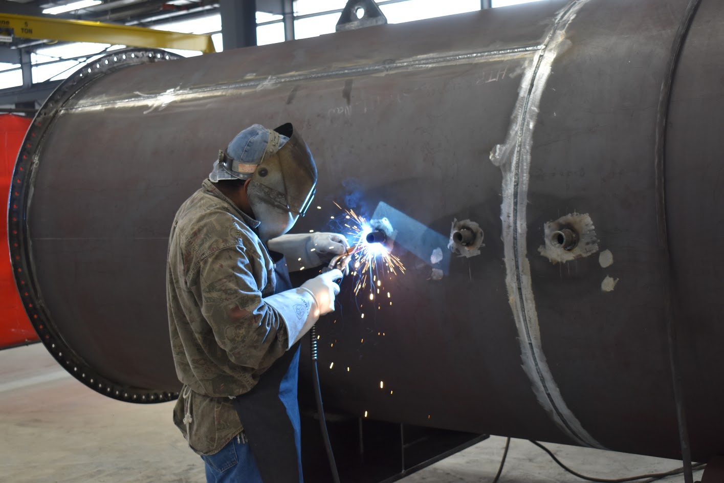 A technician working on a large steel tube